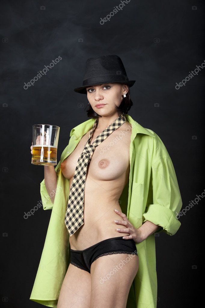 Sexy topless woman dressed in male shirt, tie and black hat, drinking